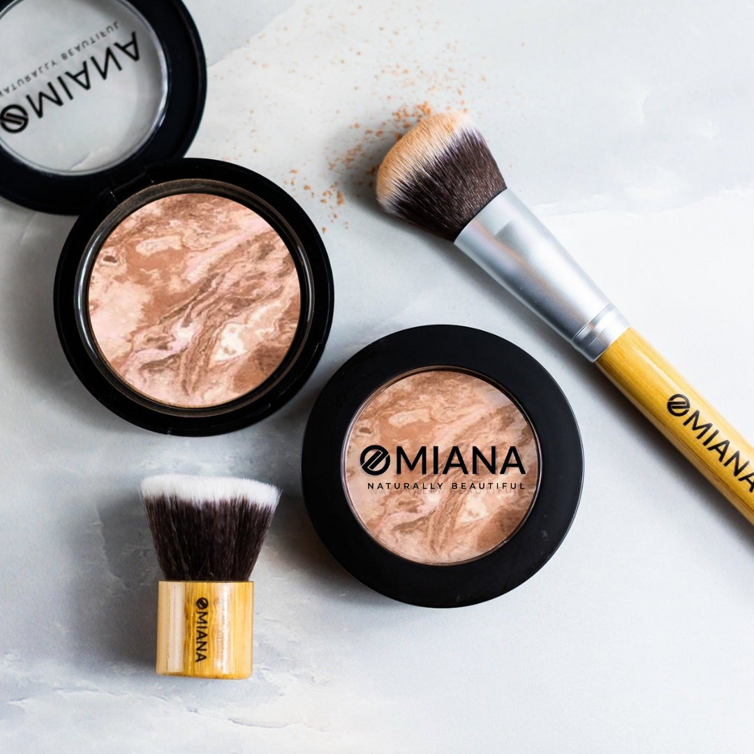OMIANA baked cream bronzer mineral makeup products and vegan bamboo brushes on a light surface
